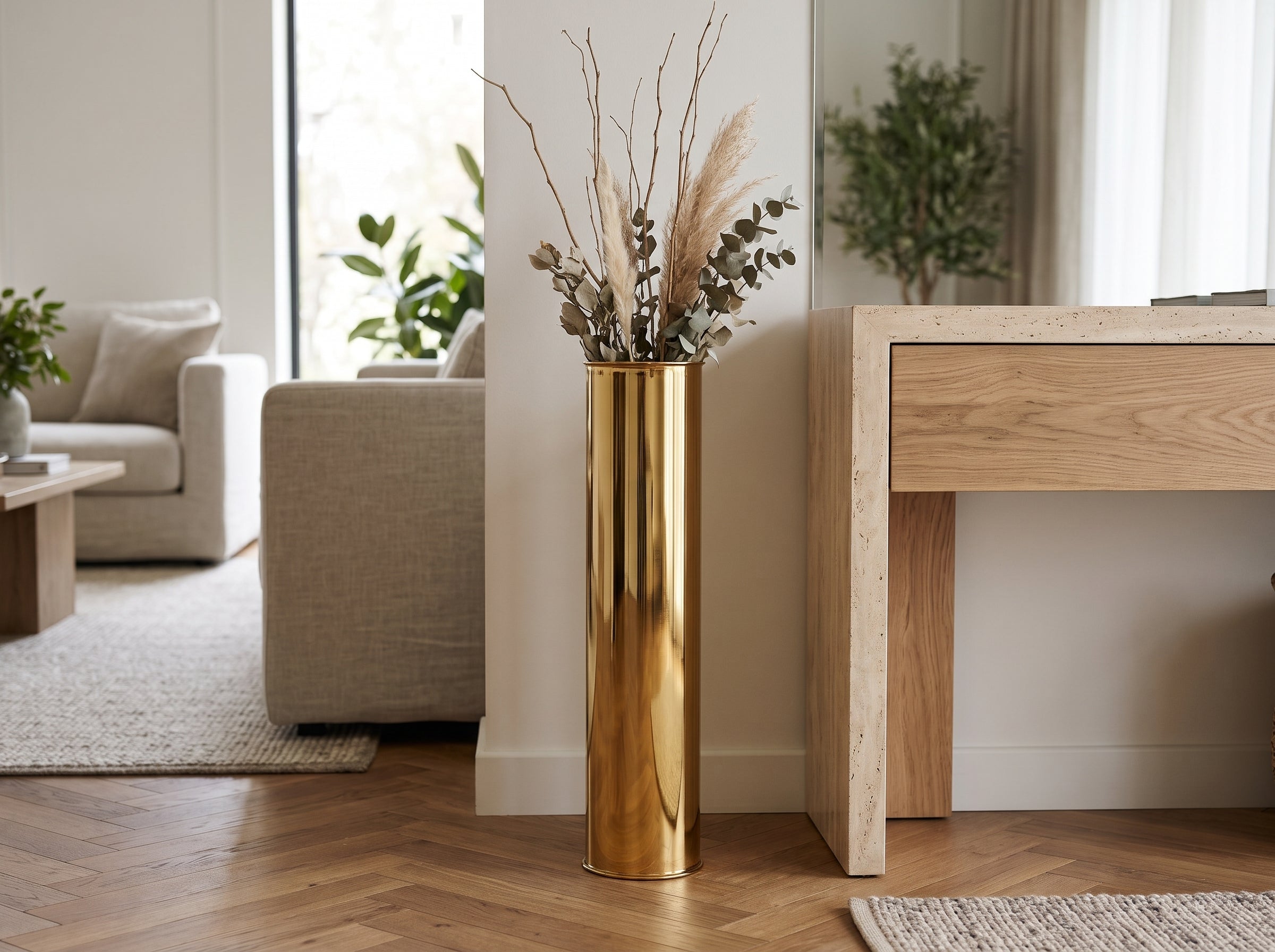 Oro Column Floor Vase in gold with pampas and eucalyptus beside a console