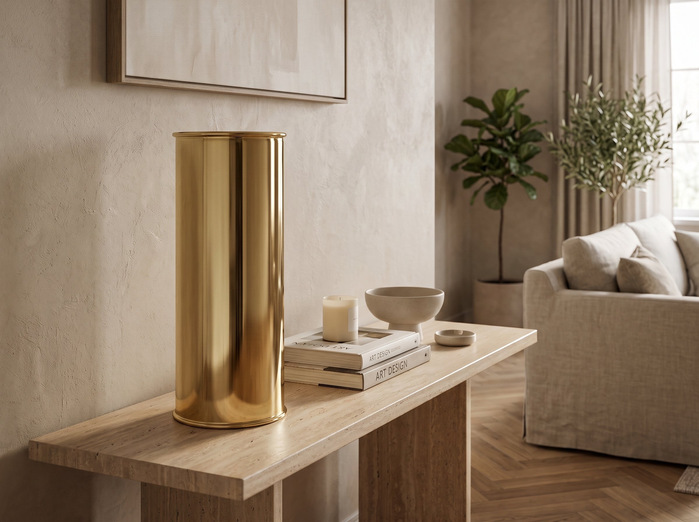 Large Oro Cylinder Vase in mirror-polished gold on a console table with books and a candle